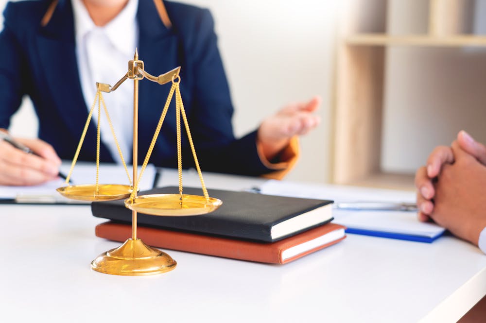 Scales of justice on a desk during a legal consultation, representing balance and fairness in law.