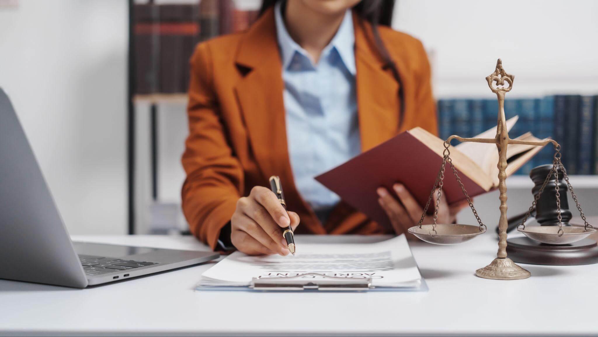 a woman sitting at a desk in front of a laptop